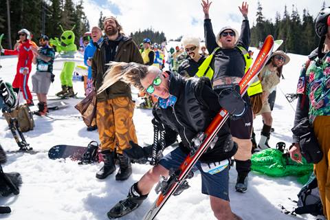 Man with a mohawk dances during a ski event. 