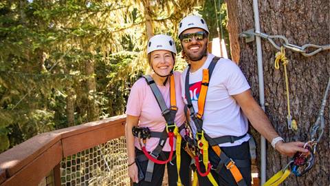 A young couple smiles as they get ready to have fun on Crystal Mountain's Adventure Course