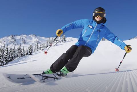 A skier displays excellent turn form on a groomed run