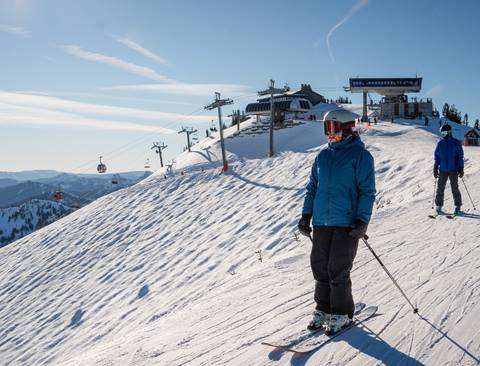 Skier with gore-tex clothes skies on a catwalk on the top of a mountain. 