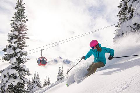 Woman skies on a powder hill.