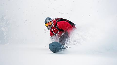 Snowboarder riding deep snow
